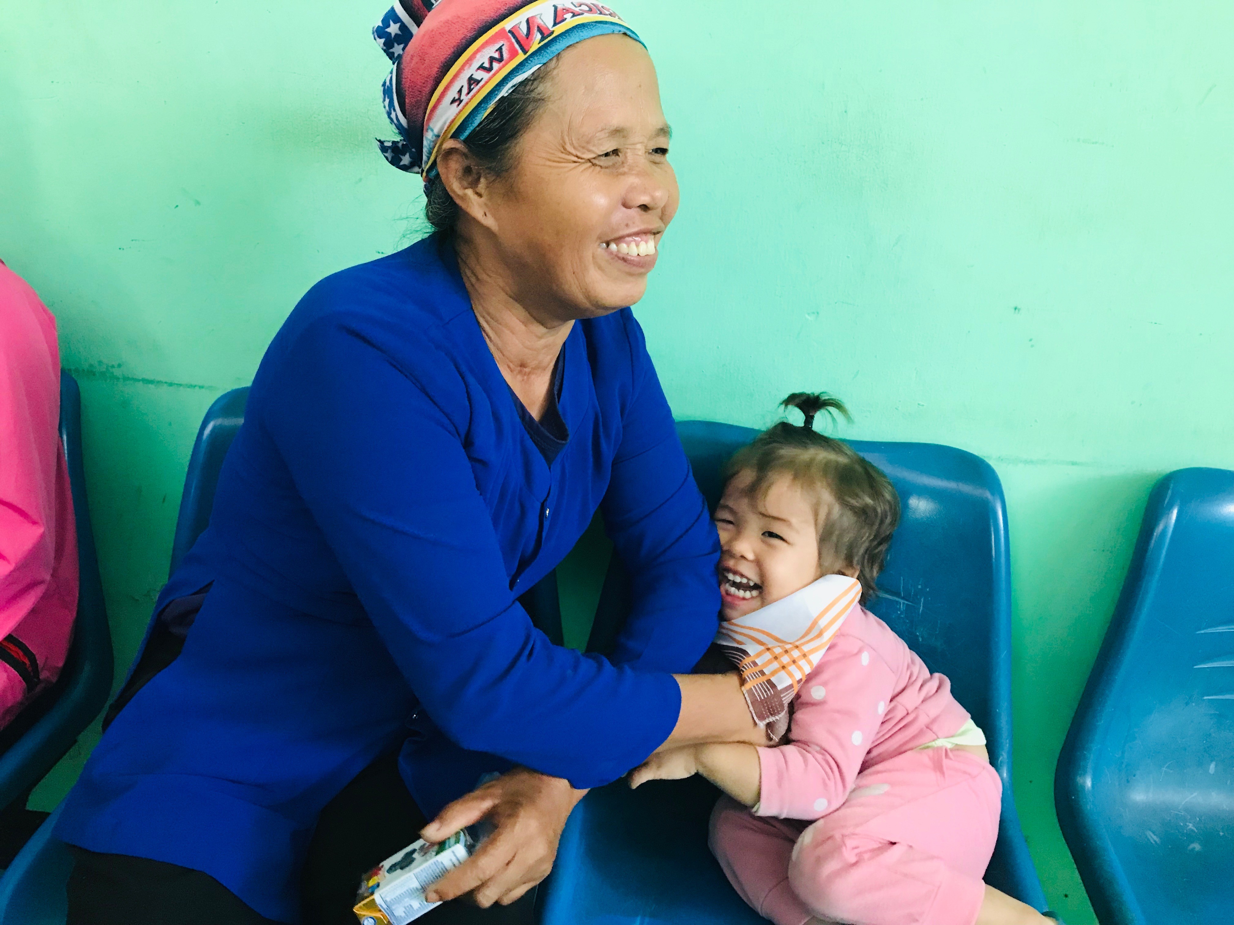 A young girl with her grandmother in Vietnam and both are smiling