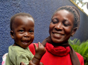 Advocacy-page-mockup Smiling caregiver holding a young boy who is also smiling