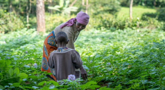 Woman and boy outside in a green meadow in Tanzania