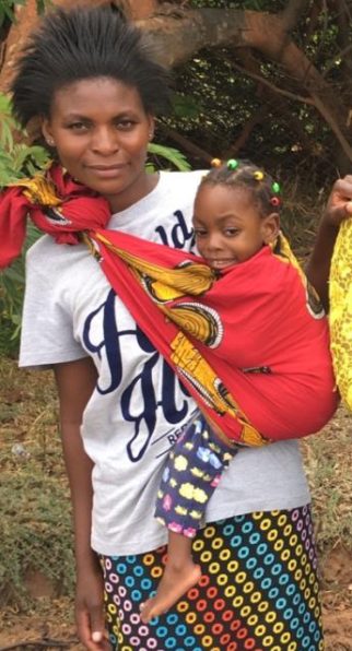 A mother in Zambia holding her daughter with disabilities in a red sling