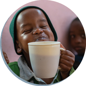 TZ-Boy-Drinking-Circle Boy in Tanzania smiling and holding a mug