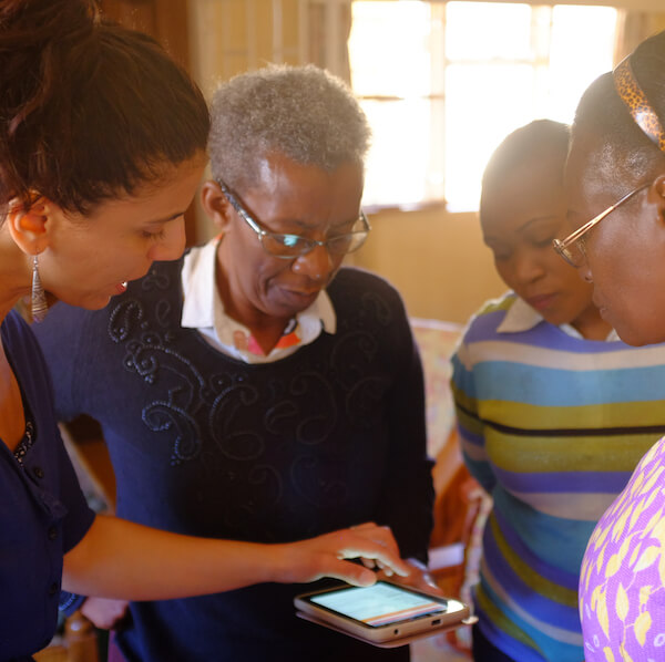 Four women looking at a mobile tablet