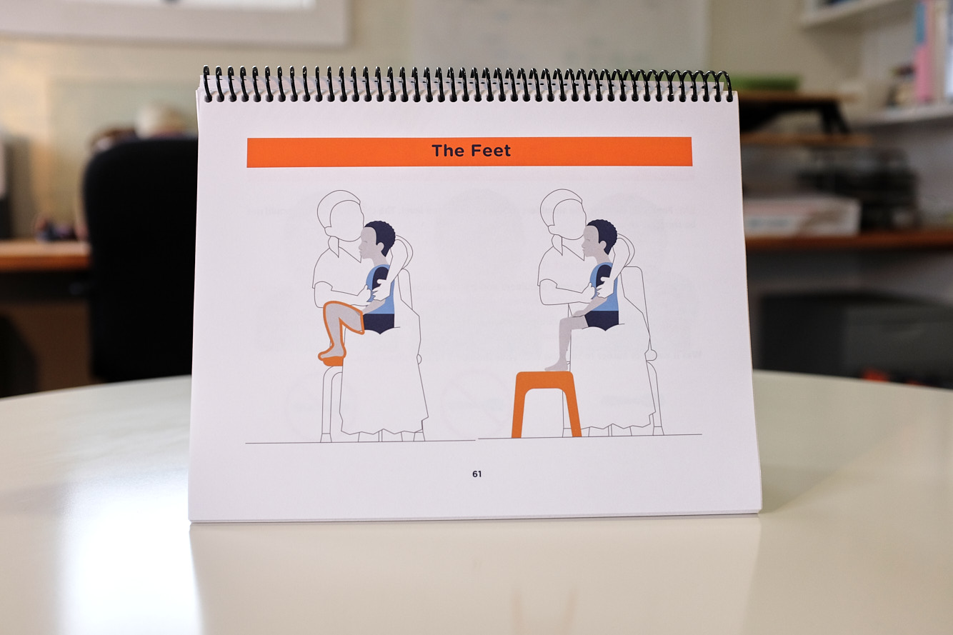 Feed-Safe-Flipbook-Page Page of the FEED Safe Flipbook showing a graphic of a caregiver properly positioning the feet of a child for safe feeding