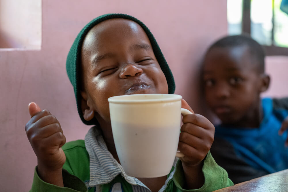 Young boy smiling and holding a mug