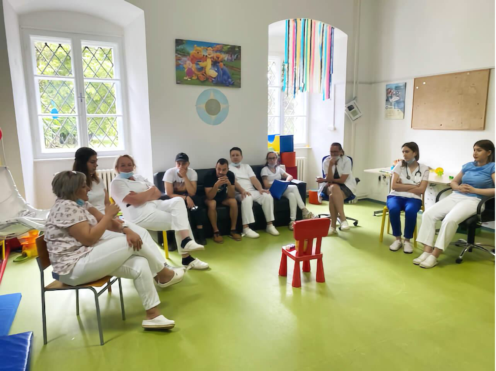 Group of ten trainees from Croatia sitting inside a daycare room in a circle