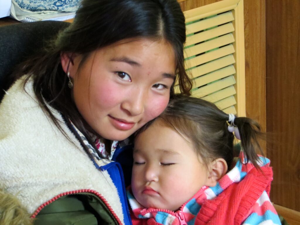 Mother holding her sleeping daughter in Mongolia